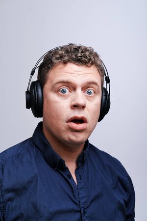 Studio portrait of a surprised rocker musician in headphonesThe concept of happiness, musicの写真素材