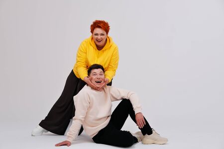 Studio portrait of funny couple posing on plain backgroundの写真素材