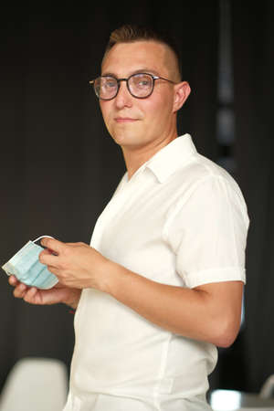 A young man puts on a medical mask. Mask - protection against viruses. The concept of medicine and...