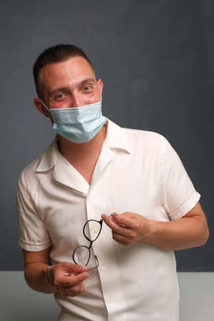 A young man puts on a medical mask. Mask - protection against viruses. The concept of medicine and health.の写真素材