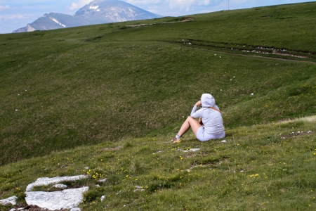 lonely girl sitting on the lawn and watching the viewの写真素材