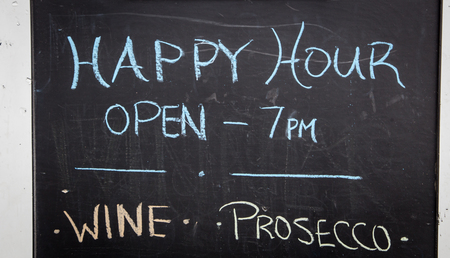Happy hour sign on a chalkboardの写真素材