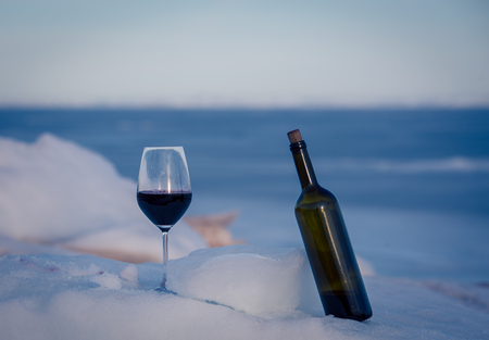 bottle of wine and glass in winterの写真素材