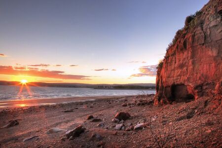 Red rocky cliffs by the ocean in Nova SCotiaの写真素材