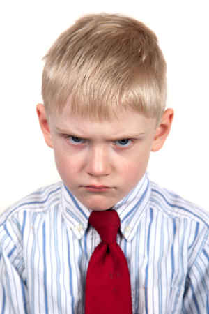 Little boy frowning angrily. Cranky face.