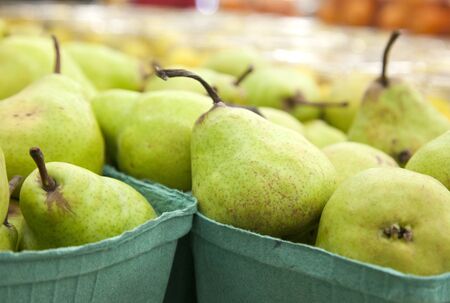 boxes of fresh green pear fruit at the marketの写真素材