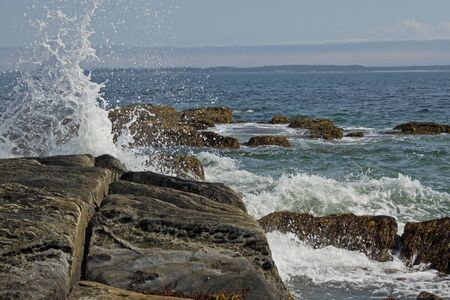 ocean spray and surf pounds against rocks on the coast