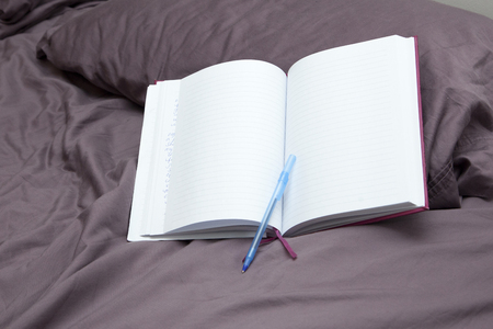 an empty page with pen on a pillow, waiting for a diary entryの写真素材