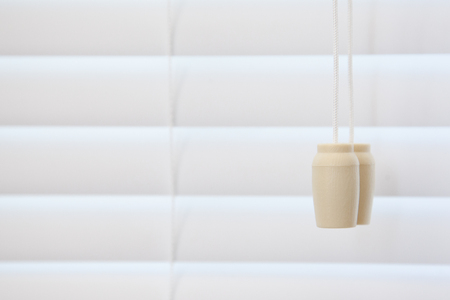 A string for pulling a blind open and closed beside a drawn shutterの写真素材