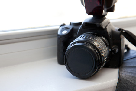 Camera and flash and strap in the window with copy spaceの写真素材