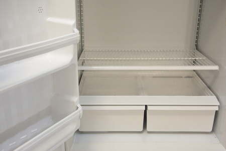 Bottom shelves and crisper in an empty refrigeratorの写真素材