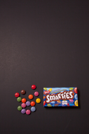 Halifax, Canada- May 31, 2019: Package of Smarties chocolate coated candy against a black backgroundのeditorial素材