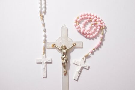 pink and white rosary beads with a golden jesus on the cross