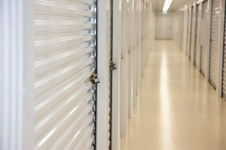 Close view of an empty storage hallway with a secured padlockの写真素材