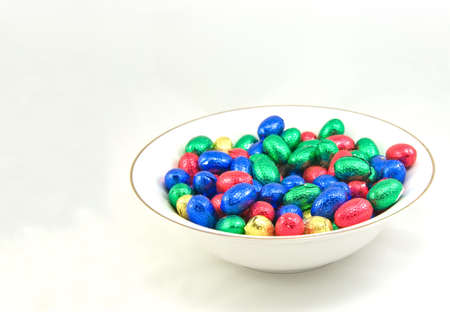 white bowl of easter eggs isolated on white backgroundの写真素材