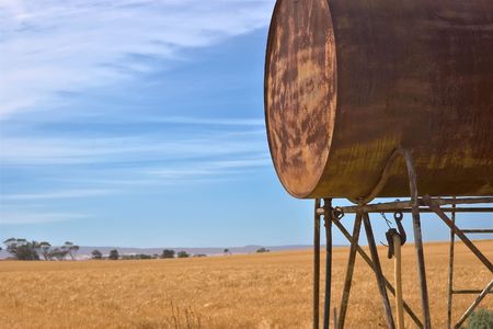 an old fuel tank and a field of wheatの写真素材