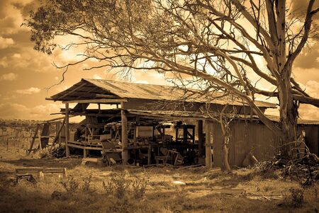 an old farm shed and equipment falling downの写真素材