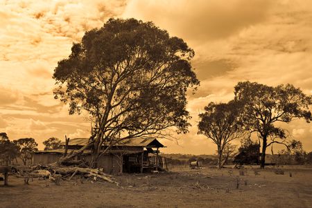 sepia style image of an old farm in disrepair with falling down shedの写真素材
