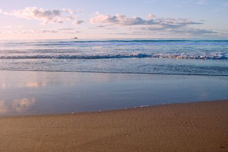 a nice beach scene with gentle waves reaching the sand の写真素材