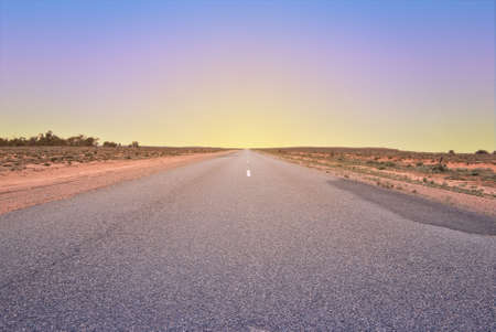 long road going into the sunset or the sunriseの写真素材