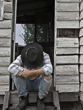 image of a depressed man sitting on steps of run down 