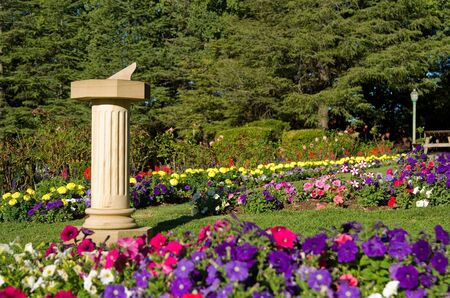 beautiful garden with sundial full of flowersの写真素材