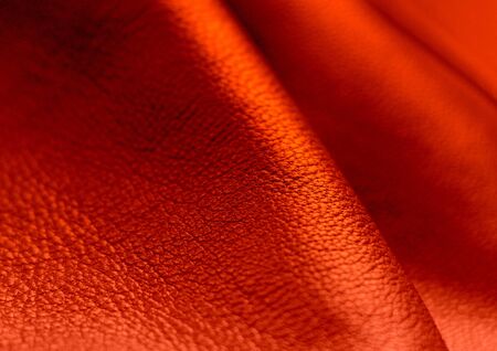 Genuine Leather. Red background. Bloody color. The texture of the skin closeup.