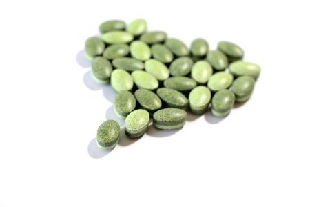 Green pills on a white background.の写真素材