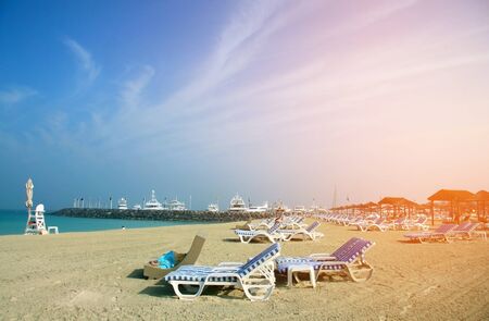 Beach landscape. Deck chairs on the sand in Dubai.の写真素材