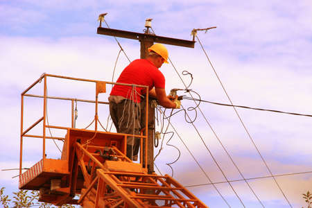 Male electrician connects power. Electrician by profession. High voltage current.の写真素材