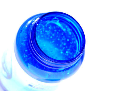 Transparent gel for moisturizing the skin in a plastic blue jar on a white background.の写真素材