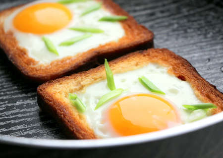 Egg in bread fried with green onions in a beautiful striped pan. Tasty breakfast.の写真素材