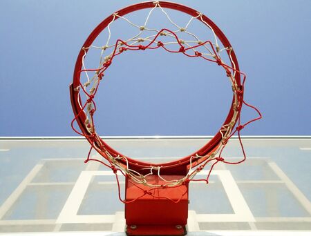 A basketball hoop, net and backboard on a playground, shot from below.                            の写真素材