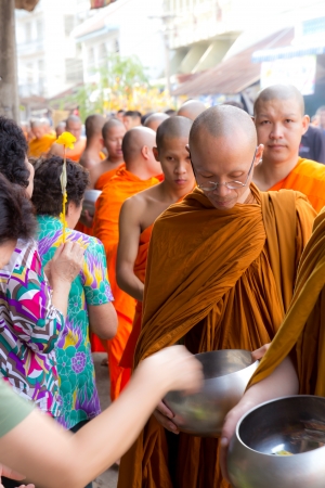 Phrae,Thailand - October 31,2012 : Unidentified Buddhist monks is given food offering from people at the morning on End of Buddhist Lent Day. on october 31, 2011 in Muang, Phrae, Thailand.のeditorial素材