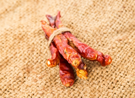 Dried chili peppers on sack backgroundの写真素材