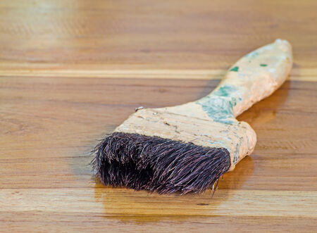 Old paint brush laying on wooden floorの写真素材