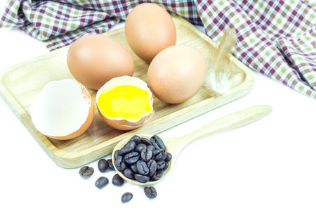 Close up egg on table cloth in wooden plate on white backgroundの写真素材