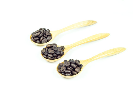Coffee beans in wooden spoon isolated on white backgroundの写真素材