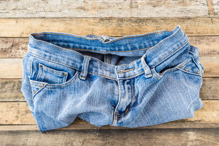 Blue jeans on old wooden surface backgroundの写真素材