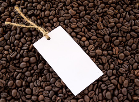 Close up white paper card on coffee beans backgroundの写真素材