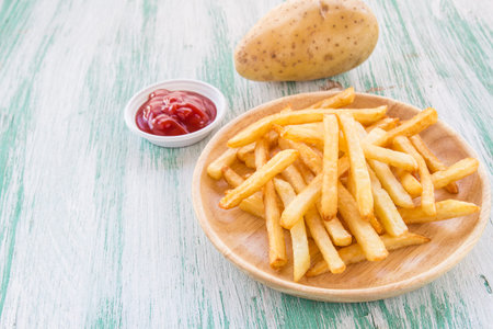 Close up french fries on a wooden background