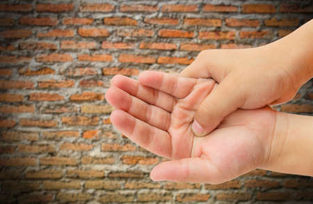 Close up hand pain with blurred brick wall backgroundの写真素材