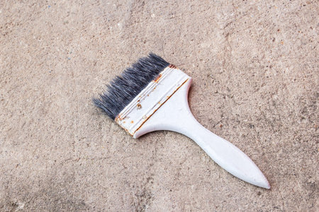 Old paint brush on the cement floor