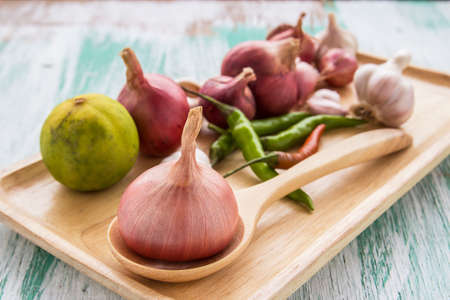 Fresh organic red onion garlic and chili on wooden table backgroundの写真素材