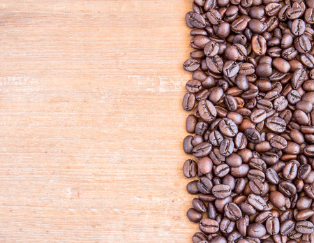 Coffee beans on wooden table background for any designの写真素材