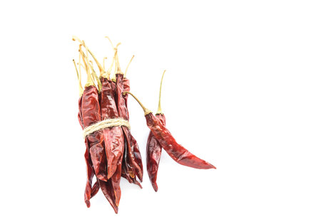Bundle of dried chili peppers on white backgroundの写真素材