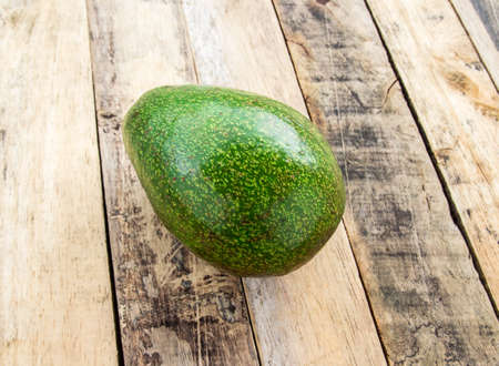 Fresh green avocado on wooden table backgroundの写真素材