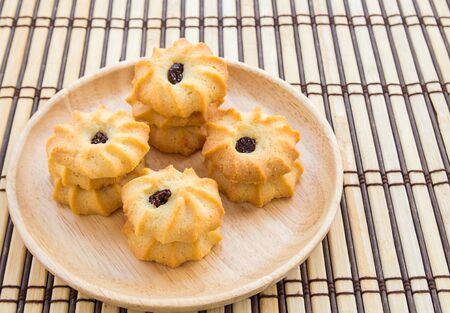 Cookies in wooden plate on wood table backgroundの写真素材