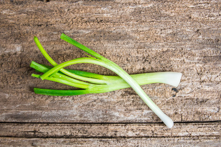 Fresh green onions on old wooden table backgroundの写真素材