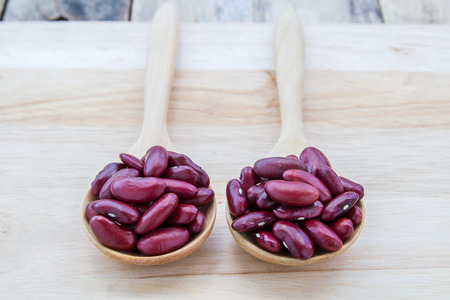 Red beans in wooden spoon on wooden table backgroundの写真素材